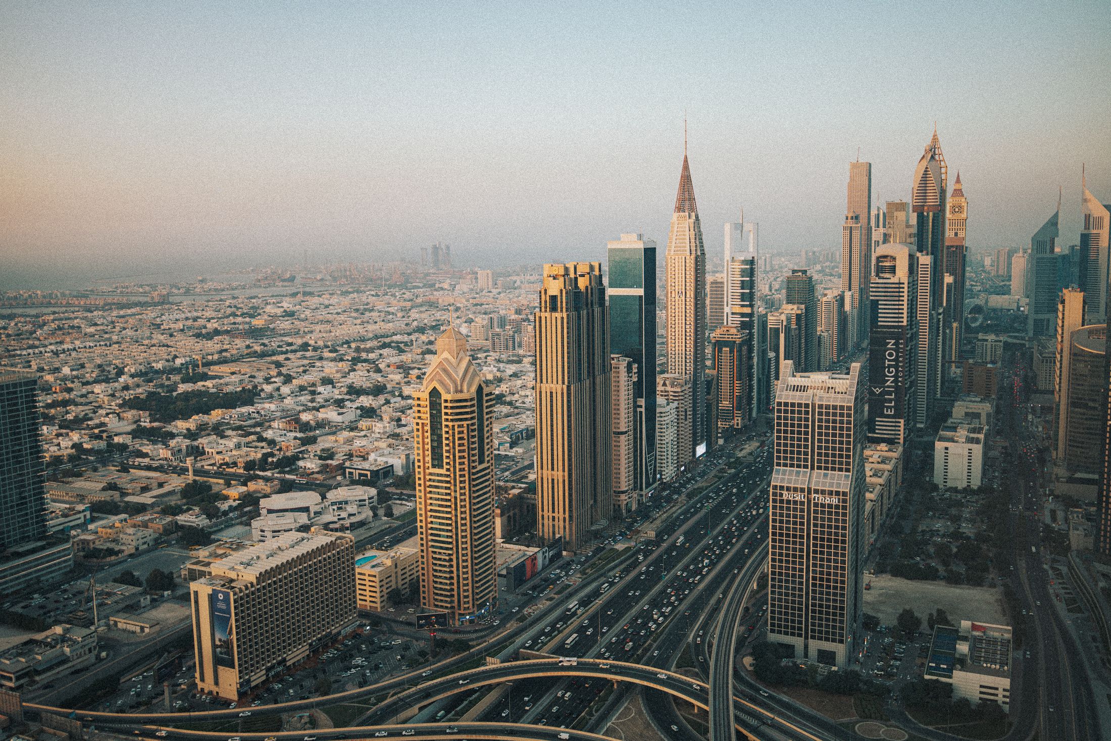 Aerial view of Dubai's modern skyline and highways at dusk