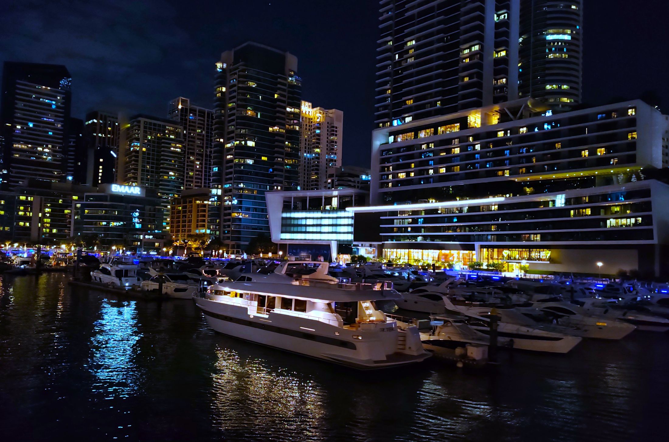 Dubai Marina at night with illuminated yachts and modern skyscrapers